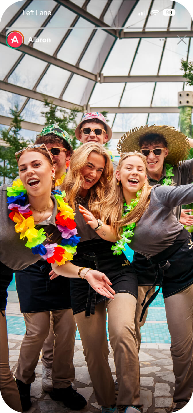 Groep jonge collega’s van Albron viert samen een werkdag met een tropisch thema tijdens hun workation, lachend en ontspannen bij het zwembad.